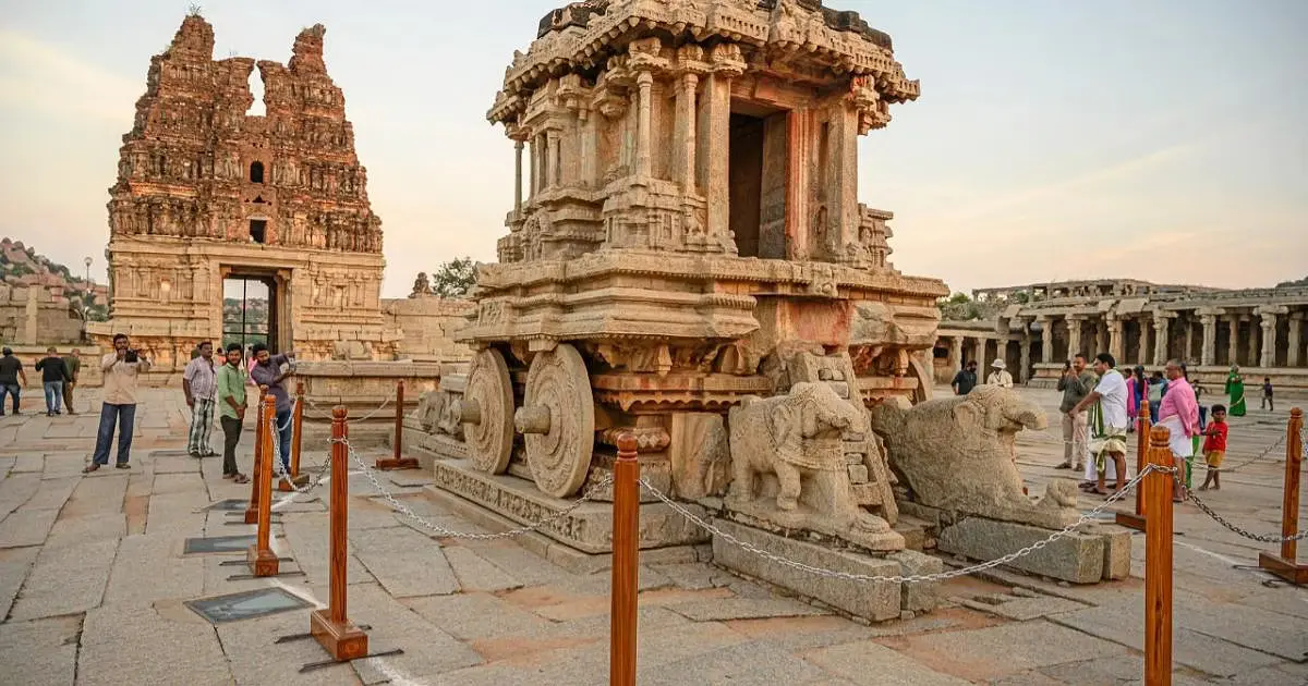 Hampi Bazaar, a bustling street with remnants of stone pillars and pavilions, offering a glimpse into the city's vibrant past.
