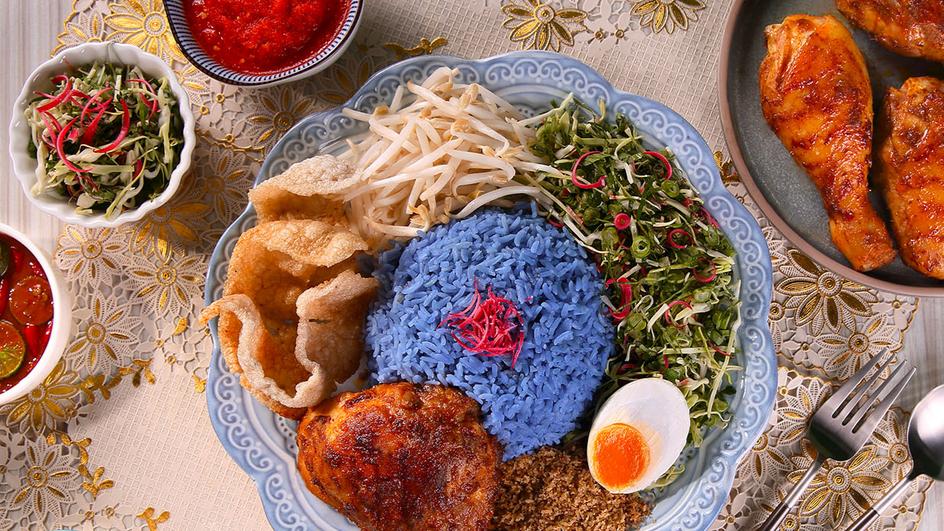 Nasi Kerabu berwarna biru cerah dengan lauk pauk yang menggugah selera: ikan goreng, telur asin, dan ulam segar